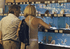 Fish shop customers looking at choice of fish